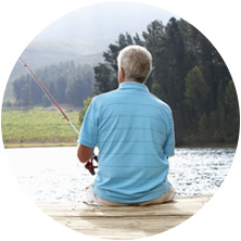 Man sitting on a dock fishing.